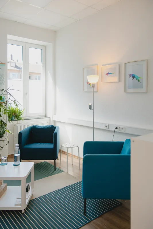 Gemütlicher Therapieraum mit blauen Sesseln