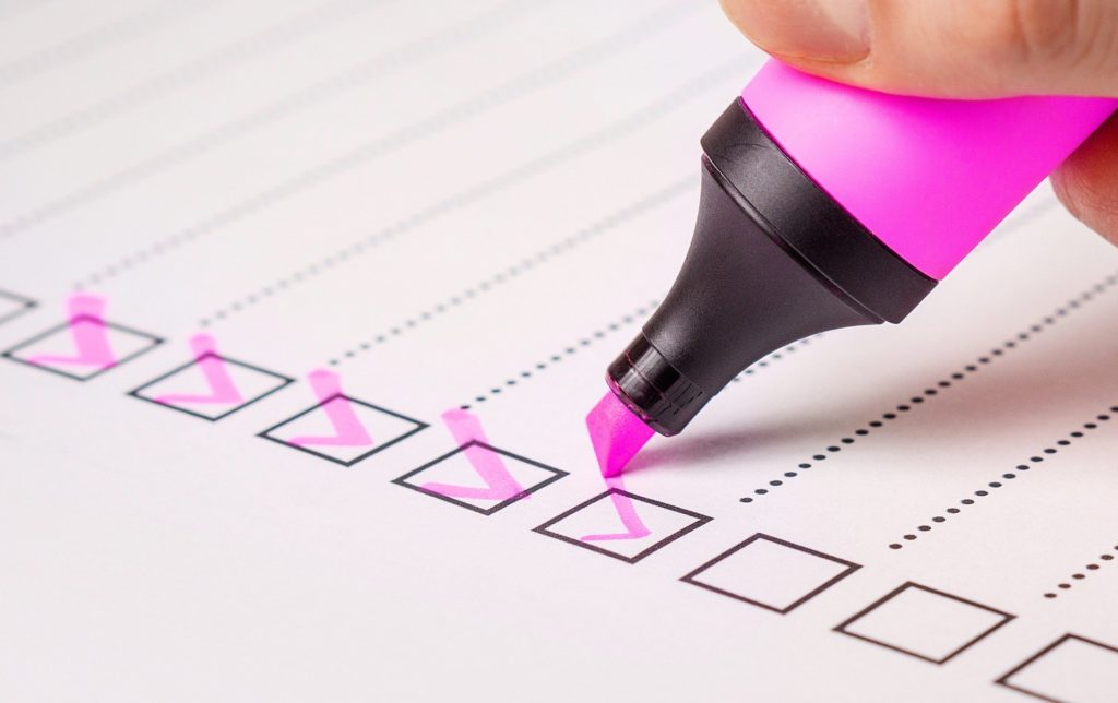 Eine Checkliste, die mit pinkem Textmarker abgehakt wird.