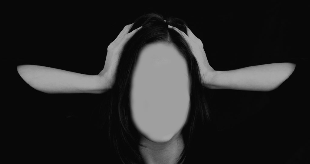 Eine Frau, die die Hände über dem Kopf zusammenschlägt und die statt eines Gesichts nur eine leere Fläche hat.